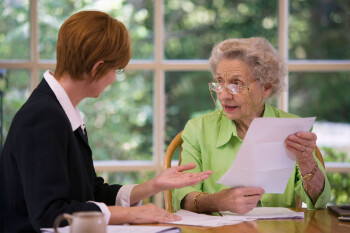 Stock Photo of Older Woman discussing a paper with a younger woman.