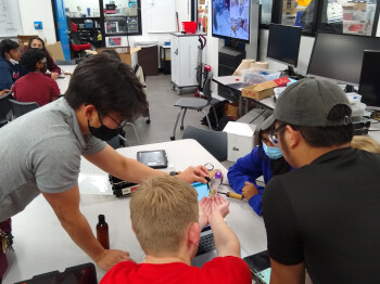 As part of the UTeach Dallas program, audiology doctoral student Sean Kashiwagura (left) taught a project-based lesson in programming during an engineering class at Coppell High School last fall. The students were designing an automatic fish feeder for small fish tanks.