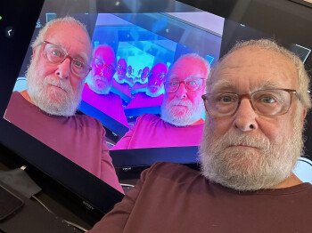 ON STAGE Fred Curchack returns to Petaluma to perform a benefit for Mercury Theater. Photo courtesy of Mercury Theater. Photo image within image of a man in front of a TV image of himself.